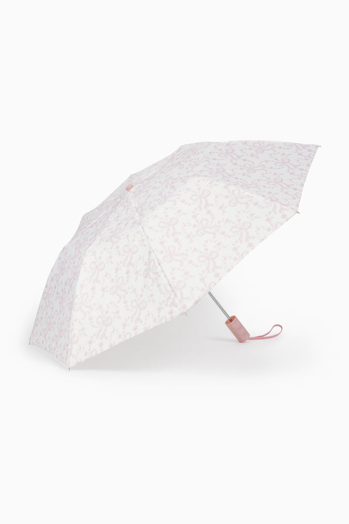 White umbrella with a subtle pink bow pattern on a white background