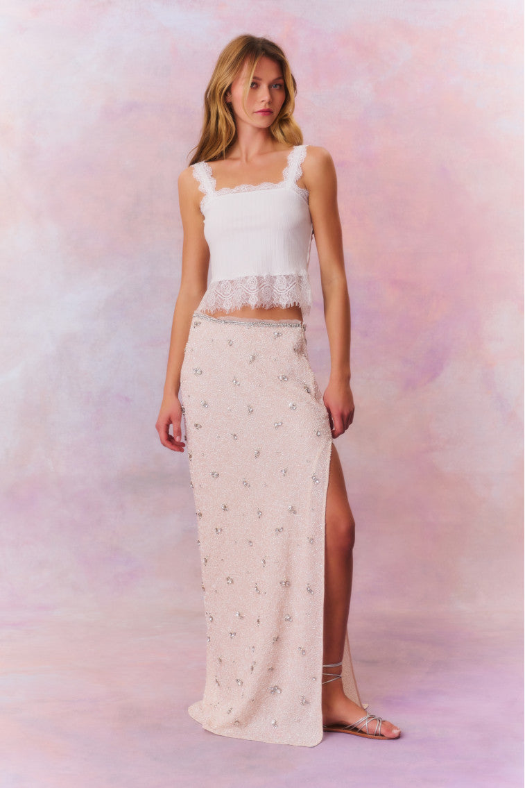 Maxi skirt featuring tiny beads that make up larger rhinestone-studded flowers dotting the skirt. Includes a side seam zipper and is finished with a slit at the wearer’s left.