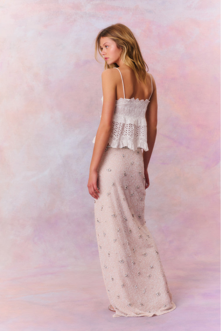 Maxi skirt featuring tiny beads that make up larger rhinestone-studded flowers dotting the skirt. Includes a side seam zipper and is finished with a slit at the wearer’s left.