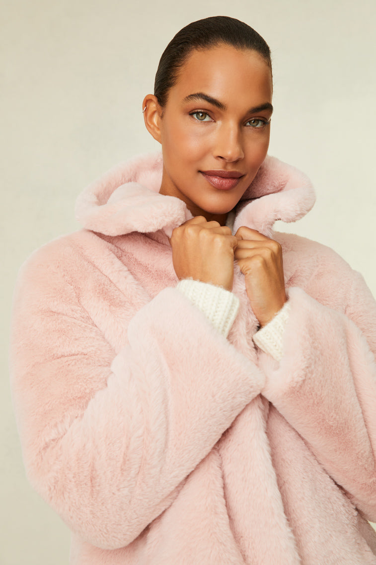 Faux fur jacket features a collar and functional buttons for closure.