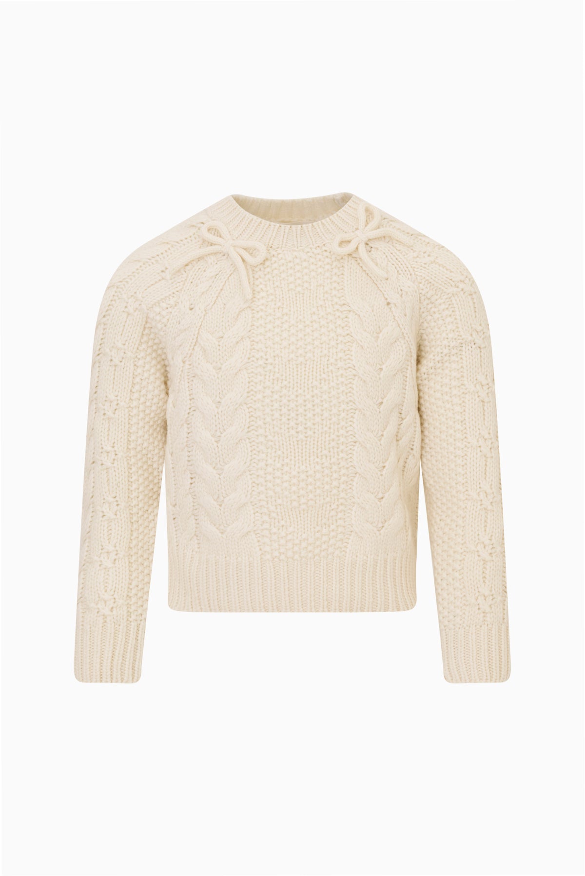 Girls cream Mavita pullover with cable knit texture, crew neck, long sleeves, ribbed cuffs and bow details at the neck