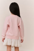 Little Girl wearing a pink american flag sweater and white skirt on a plain background