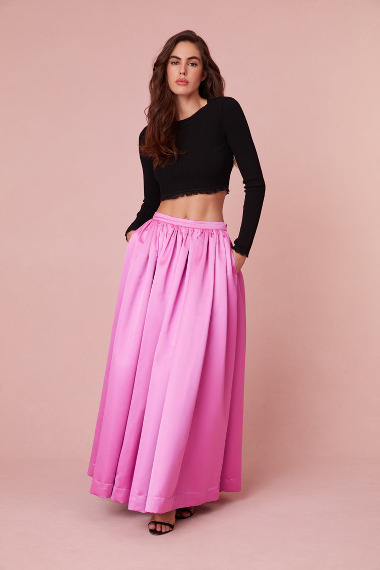 Maxi skirt features a fixed waistband before descending to a full, pleated skirt.