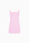 Pink slip dress with scalloped lace trim on a white background