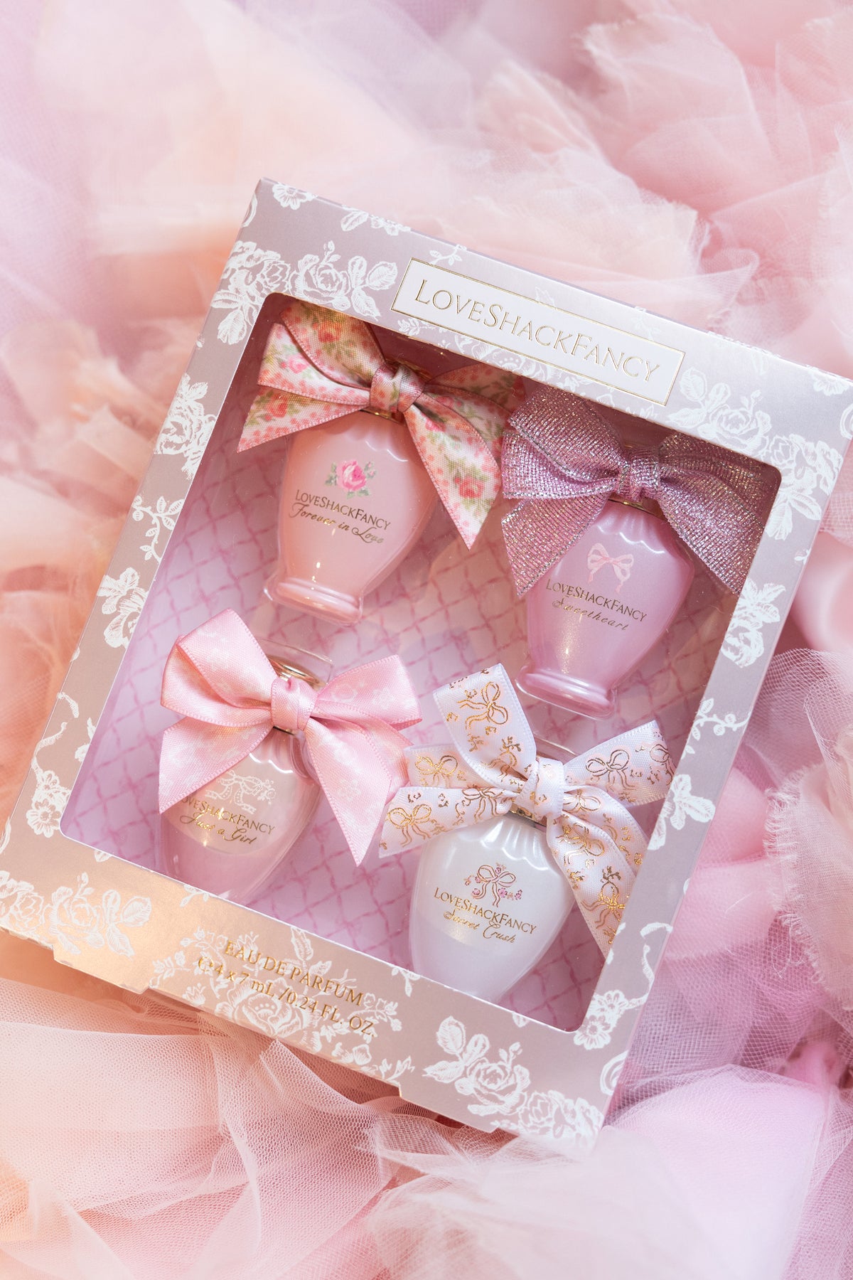 Mini perfume set gift box with four pink ribbon bows and mini bottles