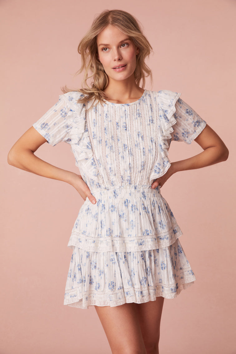 Mini dress with double ruffled flutter sleeves, which cascade down the front and back of the body to highlight the elasticated waist. Intricate custom lace panels are inset and trim the skirt’s flounces.