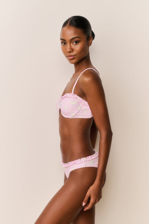 Woman wearing a pink bikini with a white background