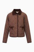 Detail view of brown quilted jacket with dark brown corduroy collar and corduroy trim, snap button front, and front pockets with velvet bow trim
