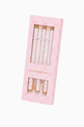 Set of pens with gold accents in a pink packaging on a white background