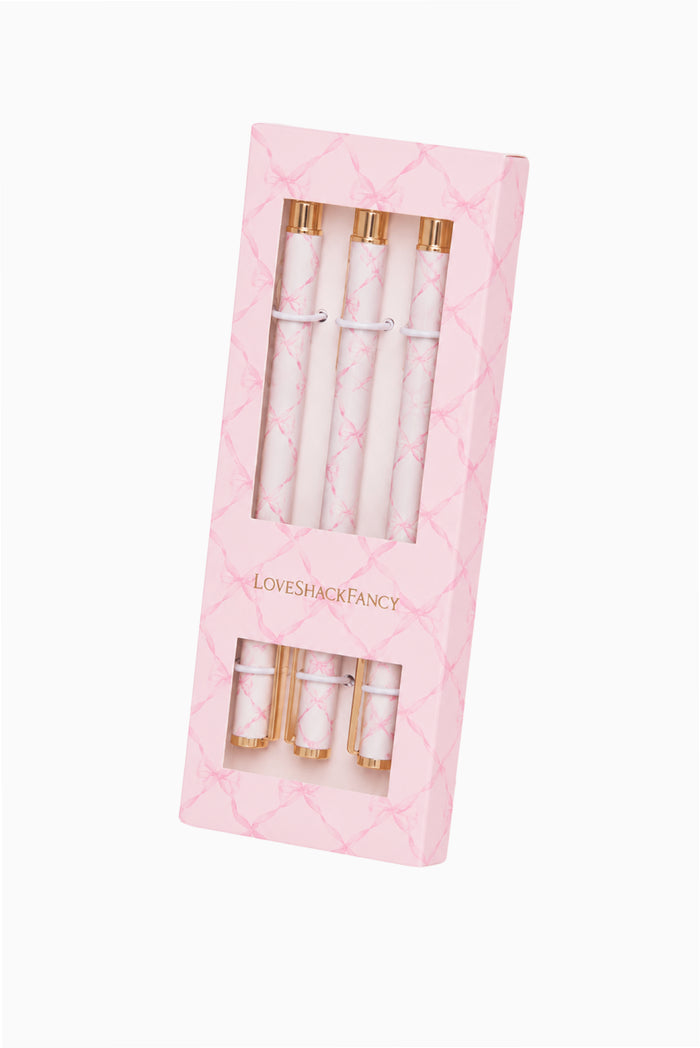 Set of pens with gold accents in a pink packaging on a white background