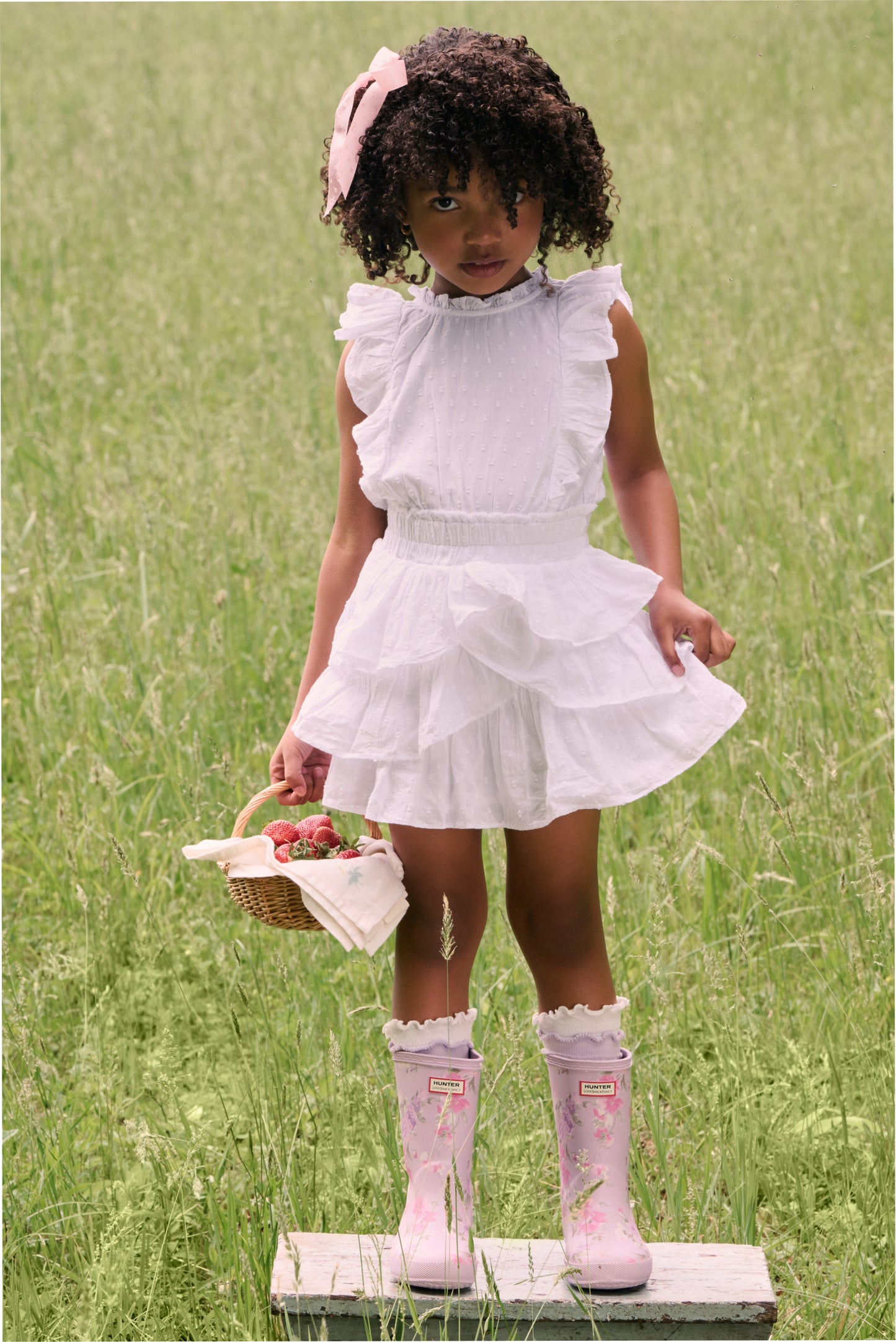 Women sitting in grass field wearing LoveShackFancy Slip Dresses