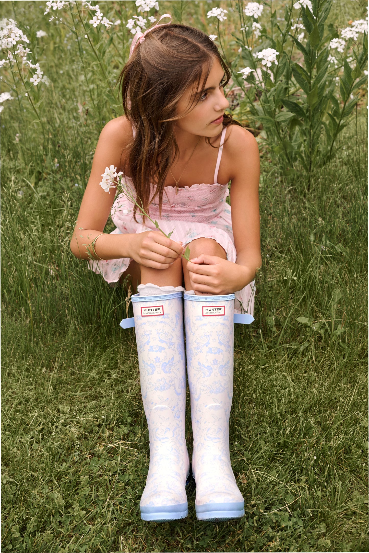 Women sitting in grass field wearing LoveShackFancy Slip Dresses
