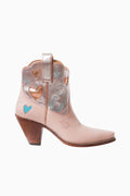 Pink cowboy boot with heart and star designs on a white background