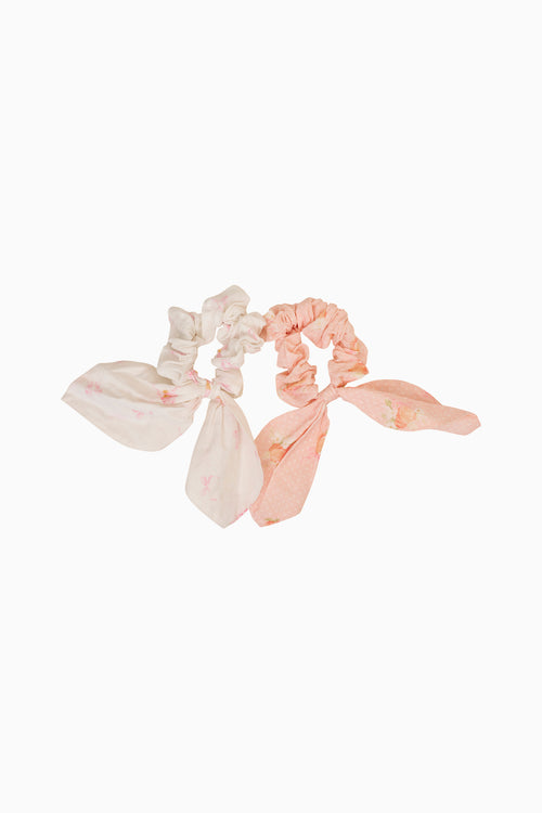 Two scrunchies, one beige and one pink, on a white background