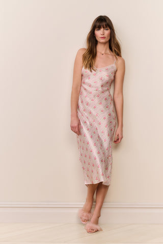 Woman wearing a floral slip dress against a plain background