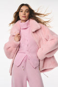 Woman wearing a pink outfit with a matching coat on a white background