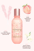 Pink bottle of LoveShackFancy product with floral and fruit illustrations on a white background