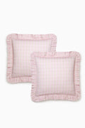 Two pink textured pillows with ruffled edges on a white background