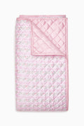 Pink quilt with floral pattern on a white background