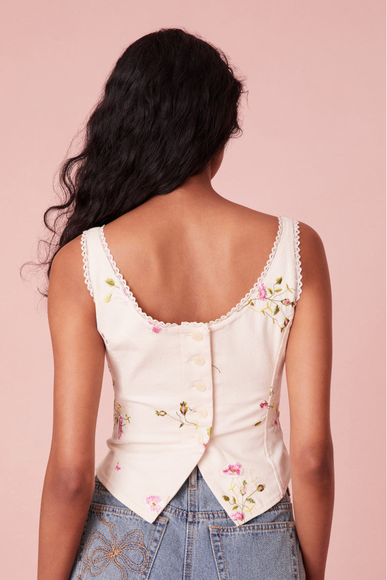 Pink floral bustier with a lace trim at the neckline, boning details for structure, and buttons for closure on the back.
