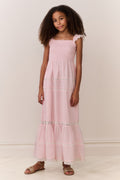Young girl wearing a pink dress with lace details on a white background