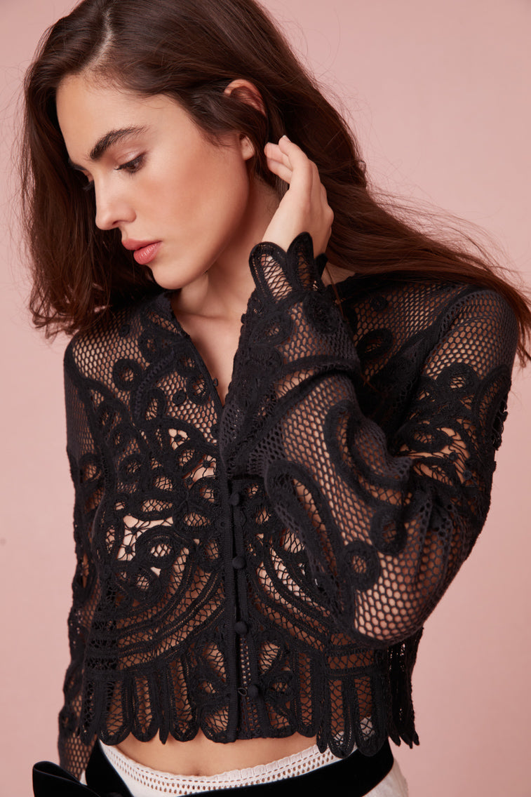 Long sleeve top with bell sleeves and lace cuffs.
