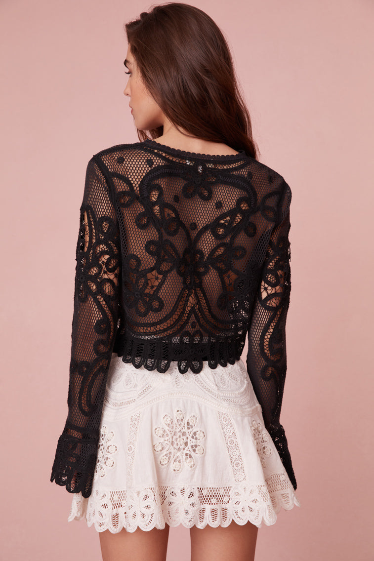 Long sleeve top with bell sleeves and lace cuffs.