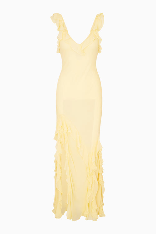 Yellow evening gown with ruffled details on a white background