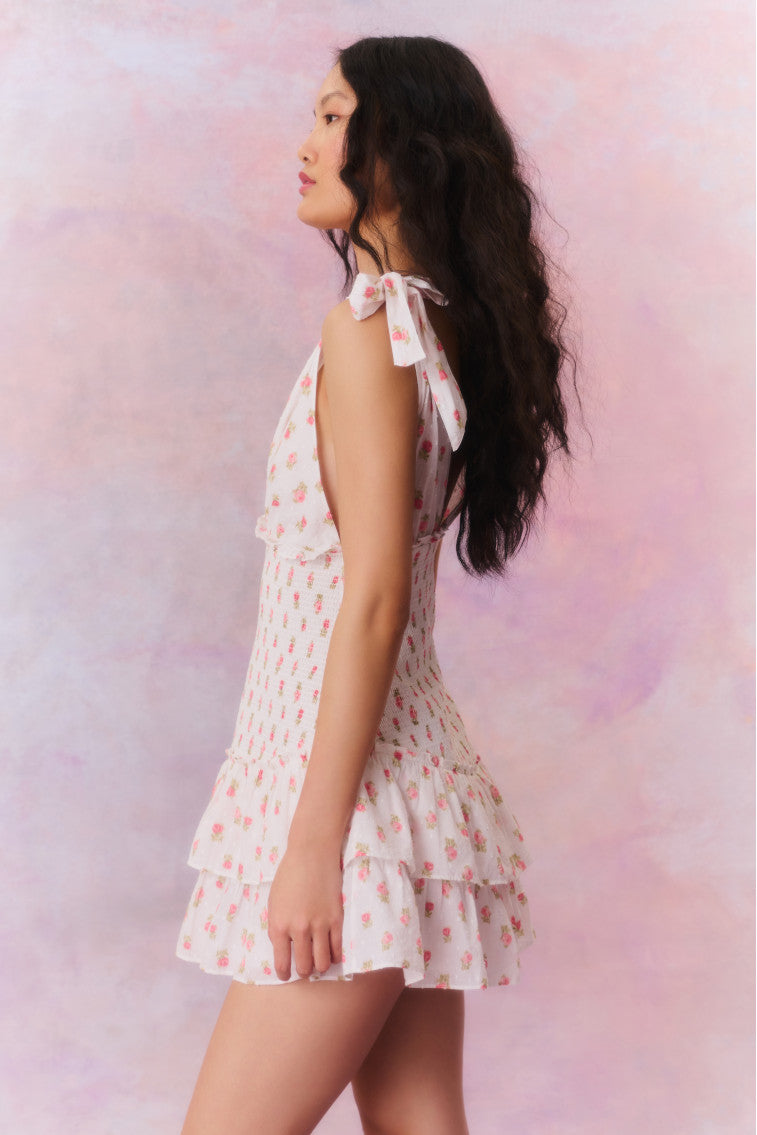 Floral printed mini halter dress with a deep v-neck above a smocked bodice descending to a sweet flutter skirt.