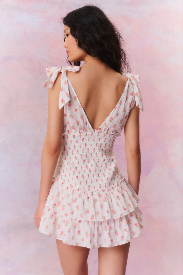 Floral printed mini halter dress with a deep v-neck above a smocked bodice descending to a sweet flutter skirt.