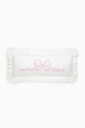 White pillow with pink text on a white background