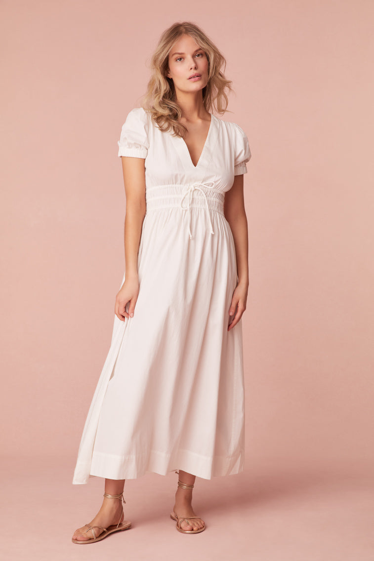 Maxi dress with short puff sleeves, a v-neckline that descends to an elasticated waist with a self-tie detail and falls to a flowy skirt.