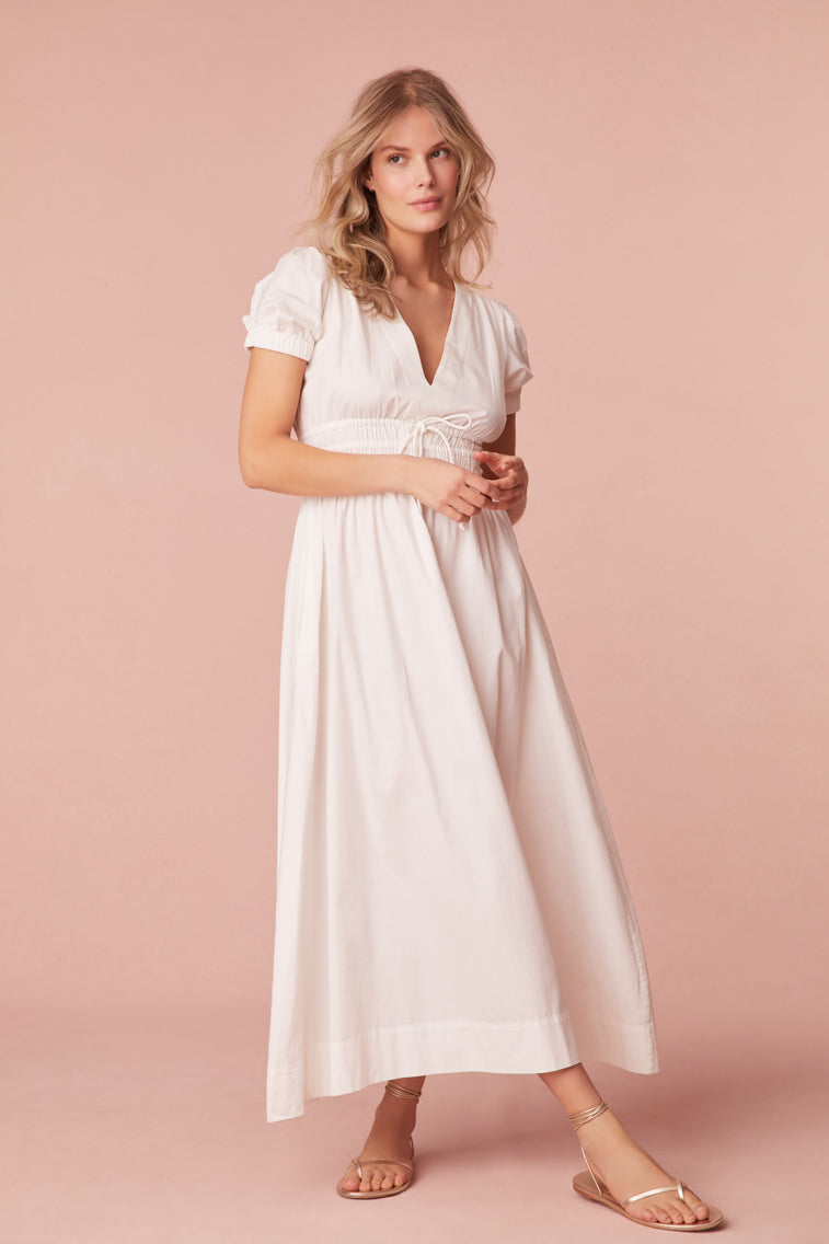 Maxi dress with short puff sleeves, a v-neckline that descends to an elasticated waist with a self-tie detail and falls to a flowy skirt.
