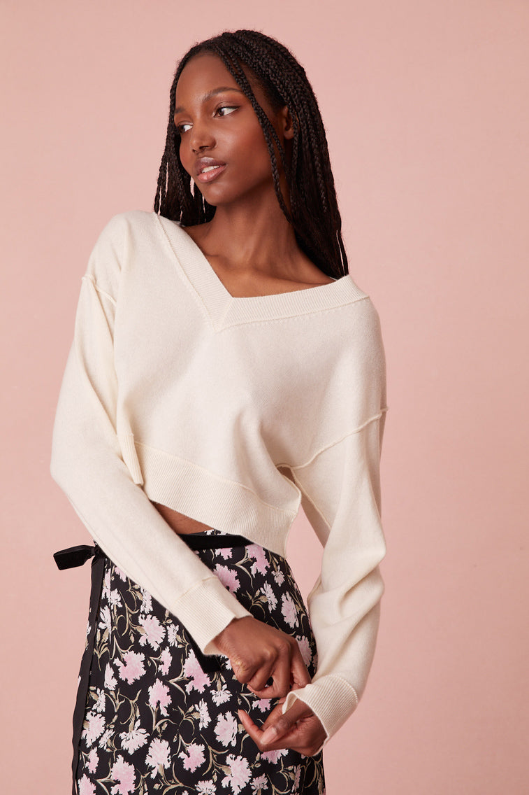This lightweight, slightly cropped knit is designed from a cashmere fabric with rib linking near the seams and sealed with a self top-applied bow on the back. 