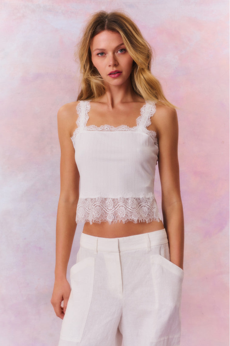 White cami top with lace trim along the bottom, the necklines, and the straps.