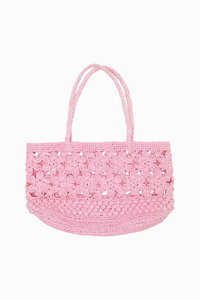Pink woven handled bag against white background