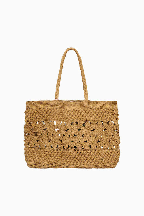 Tan woven handbag with cut-out patterns on a white background
