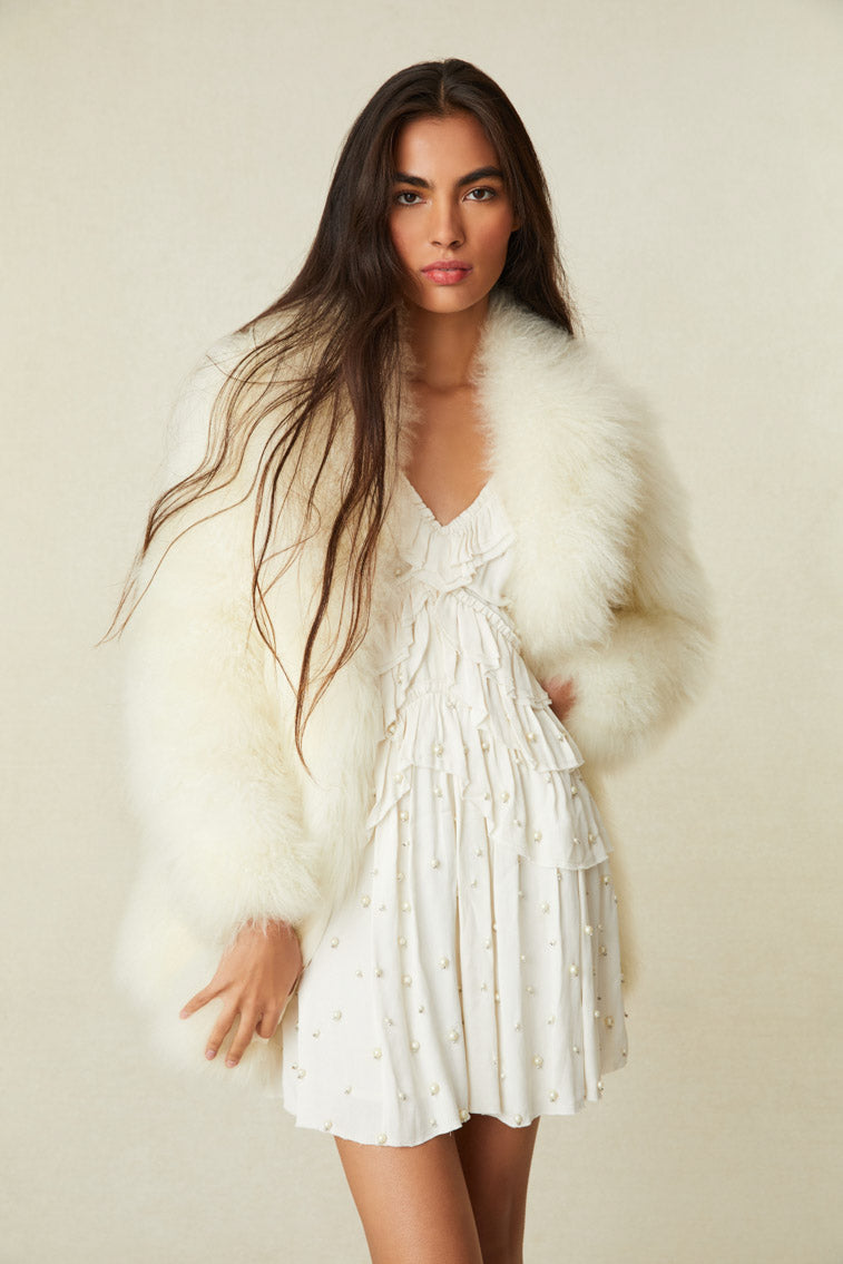 Oversized white fur coat ending at the hip.