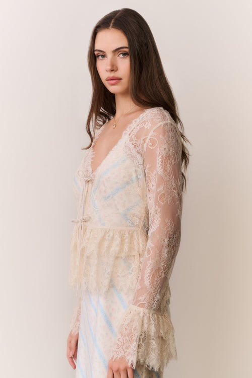 Woman wearing a lace dress with a plain background