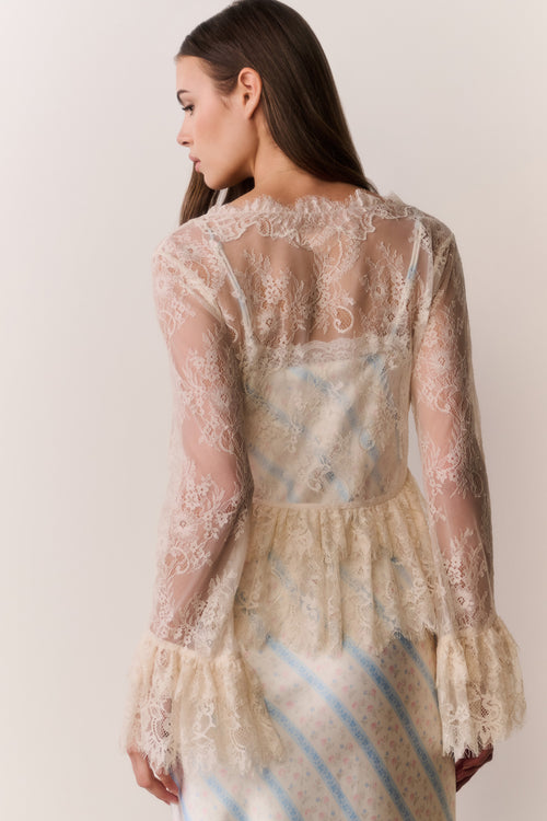 Woman wearing a sheer lace dress with a white background