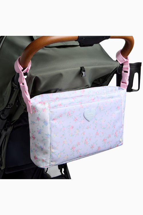 Stroller organizer with floral pattern attached to a stroller