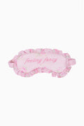Pink sleep mask with floral pattern and 'feeling fancy' text on a white background