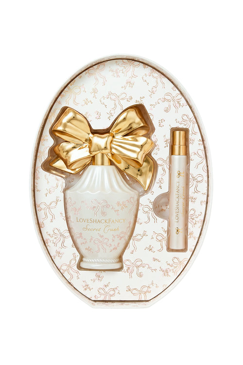 Oval gift set with white LoveShackFancy perfume bottle and gold bow plus mini spray.