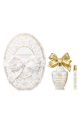 Oval LoveShackFancy gift packaging with white heart bottle and gold bow plus travel spray.