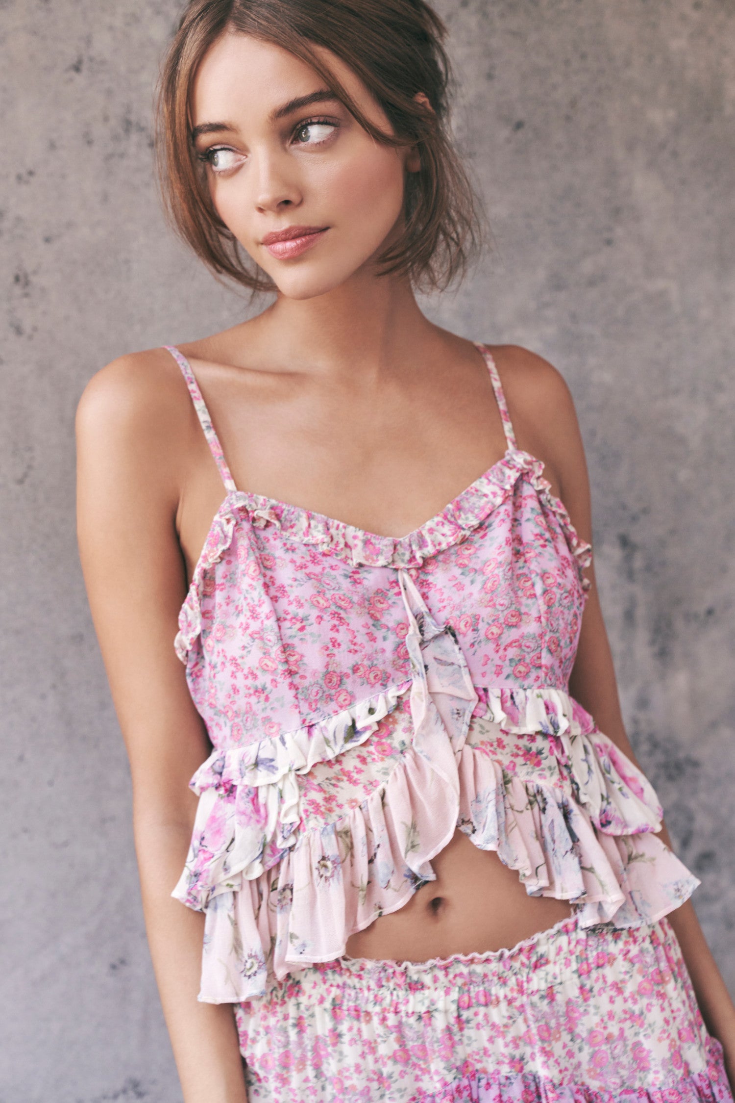 The Abbot Top is a mixed print of pink watercolor painted poppy and Victorian-inspired ditsy floral chiffon. It has spaghetti straps and a fitted waist that descends to a peplum finish and features beautiful ruffle details on the bust and the waist. 