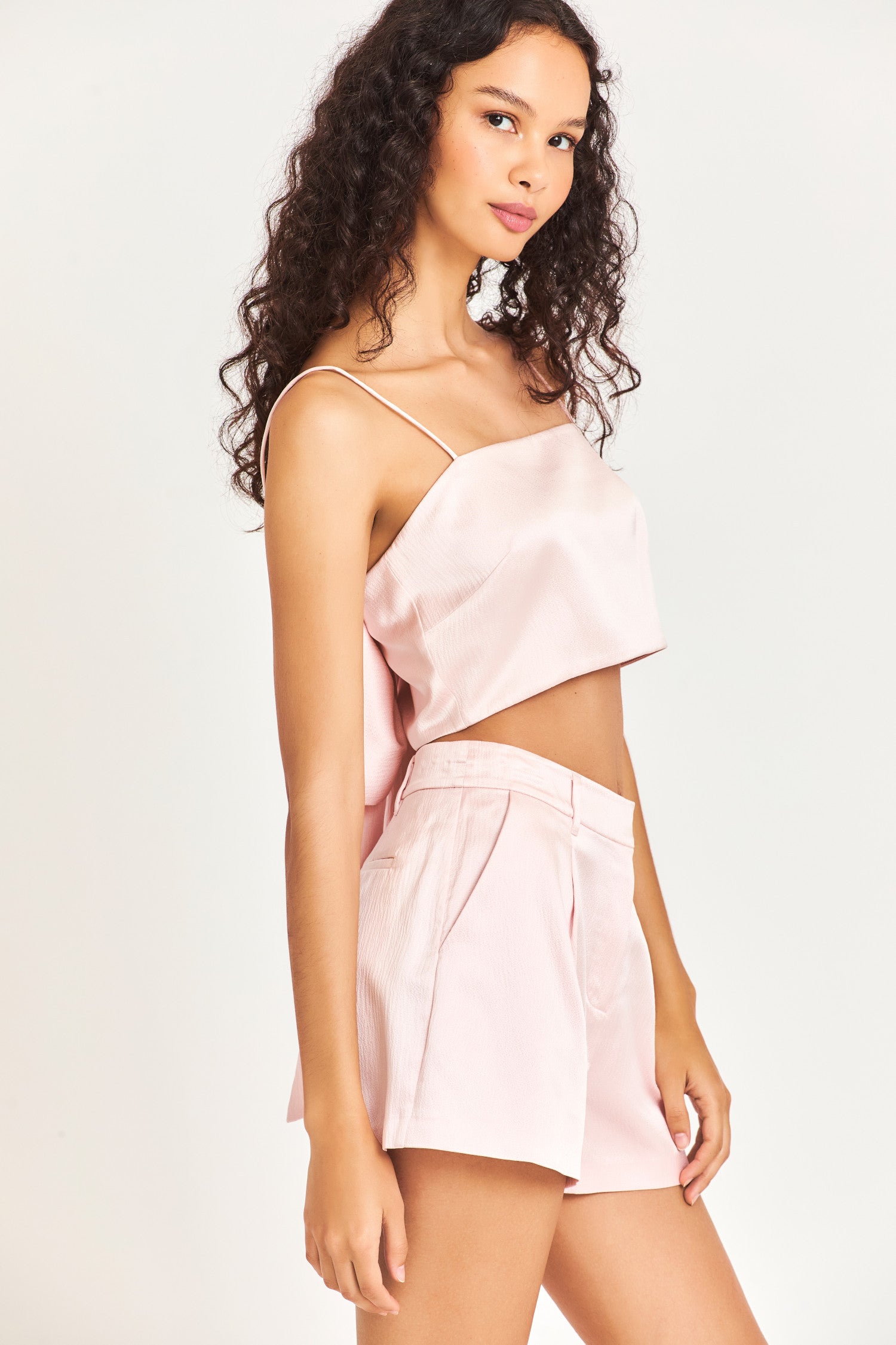 The Roasenna bandeau top is made of 100% silk and is a beautiful soft pink color. It has a side zipper, spaghetti straps, and a dramatic bow in the back. 