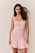 Woman wearing a pink dress against a plain background