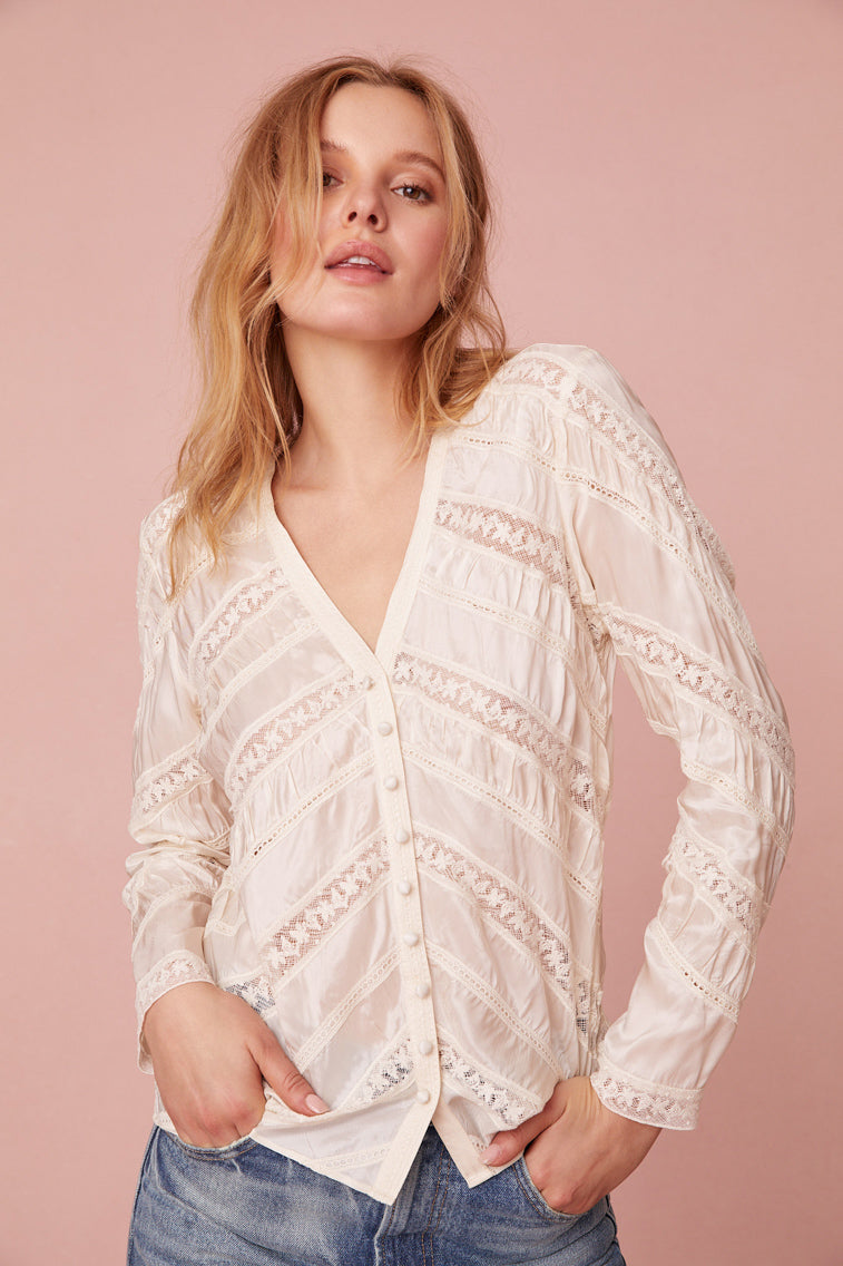 Long sleeve button down top with a v-neckline and diagonal laces for added texture detailing.