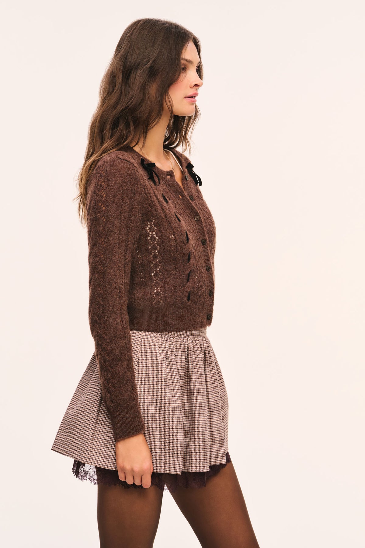 Brown and beige plaid mini skirt with gathered waist and brown lace under layer visible at the hem, side view