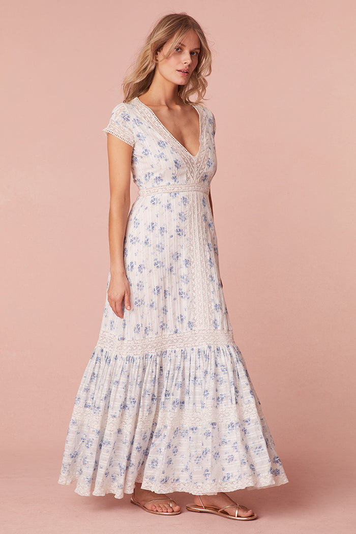 Blue floral printed midi dress featuring lace detail all over. Begins with short sleeves and a v-neckline lined with lace that descends down center front into a pleated skirt with lace insets that falls to a lace hem.